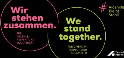 Banner mit Slogan: &bdquo;Wir stehen zusammen. F&uuml;r Vielfalt, Respekt und Solidarit&auml;t! We stand together. For diversity, respect, and solidarity! #AidshilfeBleibtStabil, Logo Deutsche Aidshilfe
